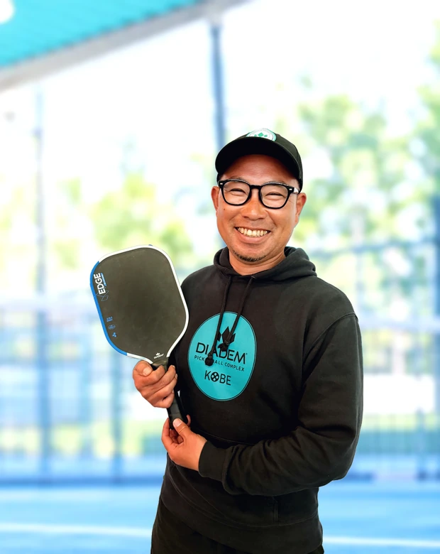 パドルを手に笑顔を見せる福井宏光コーチ